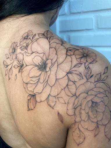 Tatuagem floral grande em fineline no ombro e costas