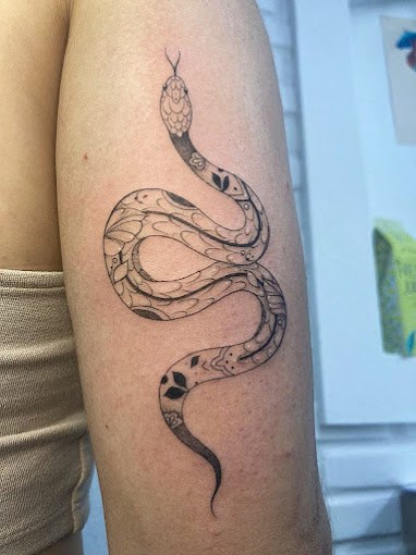 Tatuagem fineline de serpente ornamentada no braço